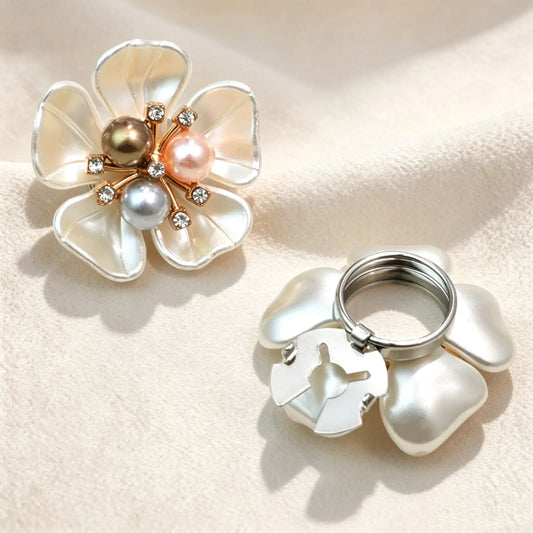 French-style pearlescent white floral button cover featuring a unique cluster of three mixed-color pearls in bronze, pink, and silver tones. Paired with a view of the open silver attachment clip.