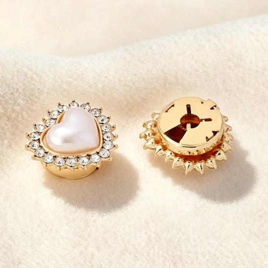 Close-up of a perfectly scaled gold pearl heart faux cufflink on a cream background. The image highlights the secure closed backing, ensuring the accessory lays flat against the cuff for a seamless, zero-bulk jewelry finish.