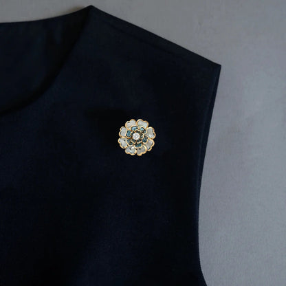 An elegant styling shot demonstrating the versatile 2-in-1 design of our floral accessory, worn here as a chic brooch pin on a black garment. Featuring light blue and white layered petals with gold edges, it adds an effortless light luxury touch to minimalist outfits.