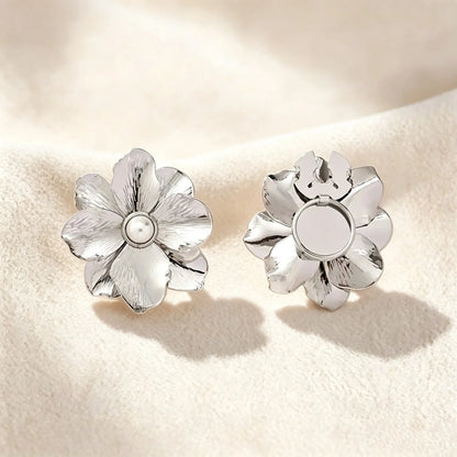 Minimalist brushed silver floral button cover with a pearl core. Displayed with the attachment clip fully open against a soft cream white background, perfect for a subtle, everyday quiet luxury cuff transformation.