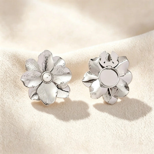 Minimalist brushed silver floral button cover with a pearl core. Displayed with the attachment clip fully open against a soft cream white background, perfect for a subtle, everyday quiet luxury cuff transformation.