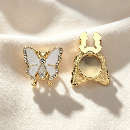 Light luxury white enamel butterfly button cover accented with a brilliant marquise crystal. Accompanied by a clear view of the open gold attachment clip, offering an effortless and whimsical cuff upgrade.