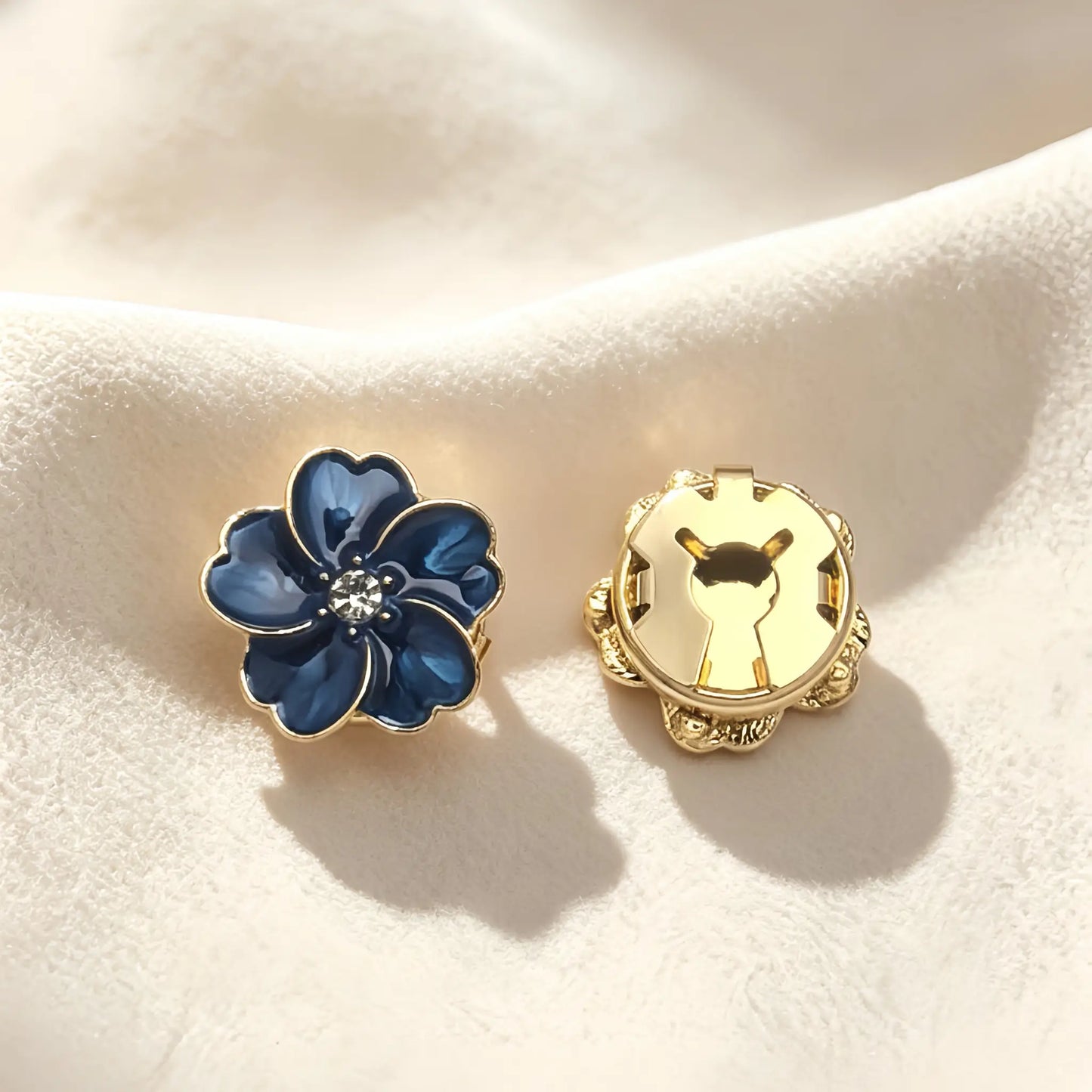 Luxurious deep blue enamel button cover with gold outlines and a central rhinestone. The image highlights the closed gold clip back, ensuring a secure fit when worn as a sophisticated faux cufflink.