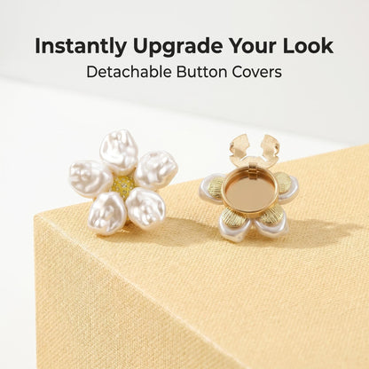 Promotional display of two detachable baroque pearl floral button covers resting on a minimalist cream textured block. The left cover displays the elegant pearl front, while the right shows the open gold clip mechanism. Overlay text reads "Instantly Upgrade Your Look - Detachable Button Covers".