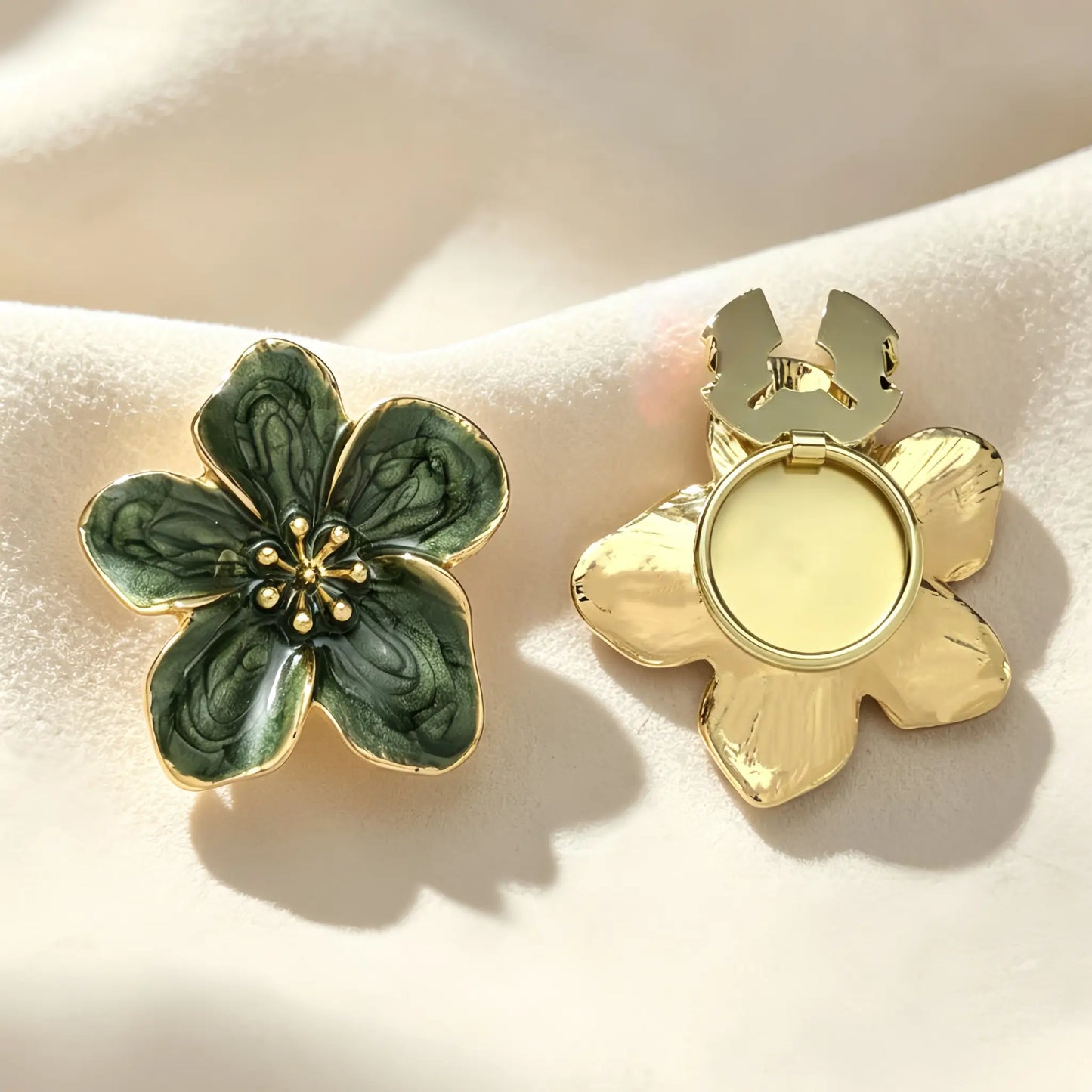Sophisticated emerald green enamel floral button cover with striking gold outlines and rich inner textures. The image shows the gold attachment clip fully open, demonstrating how easily it snaps over standard shirt buttons.