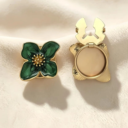 Elegant emerald green enamel four-petal floral button cover featuring gold edges and a textured gold stamen. The right piece shows the open gold hinge mechanism, perfect for use as a vintage-style faux cufflink.