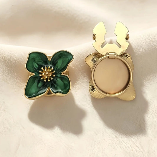 Elegant emerald green enamel four-petal floral button cover featuring gold edges and a textured gold stamen. The right piece shows the open gold hinge mechanism, perfect for use as a vintage-style faux cufflink.
