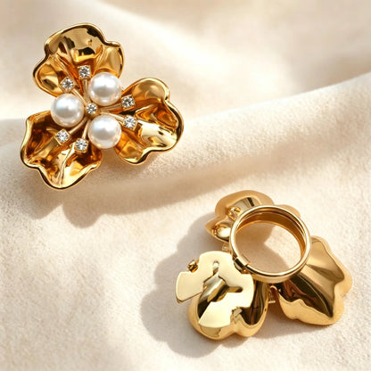 Light luxury glossy gold three-petal floral button cover adorned with three classic white pearls and rhinestones. Displayed on soft fabric with the gold hinge fully open, demonstrating an easy no-sew shirt cuff upgrade.