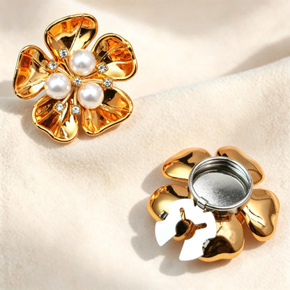 High-shine glossy gold floral button cover centered with three white pearls and sparkling rhinestones. Includes a detailed view of the gold open clasp back, designed to securely fit over standard shirt cuffs.