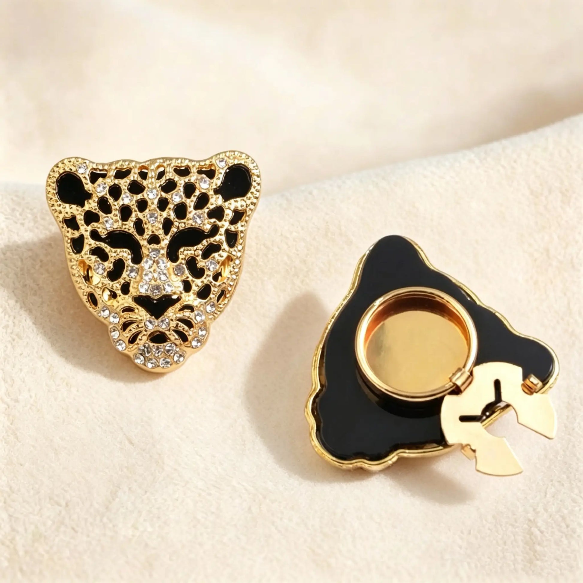 A luxurious gold-toned leopard head button cover encrusted with crystals, shown beside its functional clip-on base for a bold wardrobe renewal.