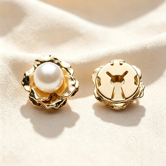 Gentle matte blush pink enamel floral button cover, featuring unique mixed-color pearls and gold accents. The lower piece displays the open gold hinge mechanism on soft textured fabric under warm sunlight. Perfect as an elegant, no-sew faux cufflink.