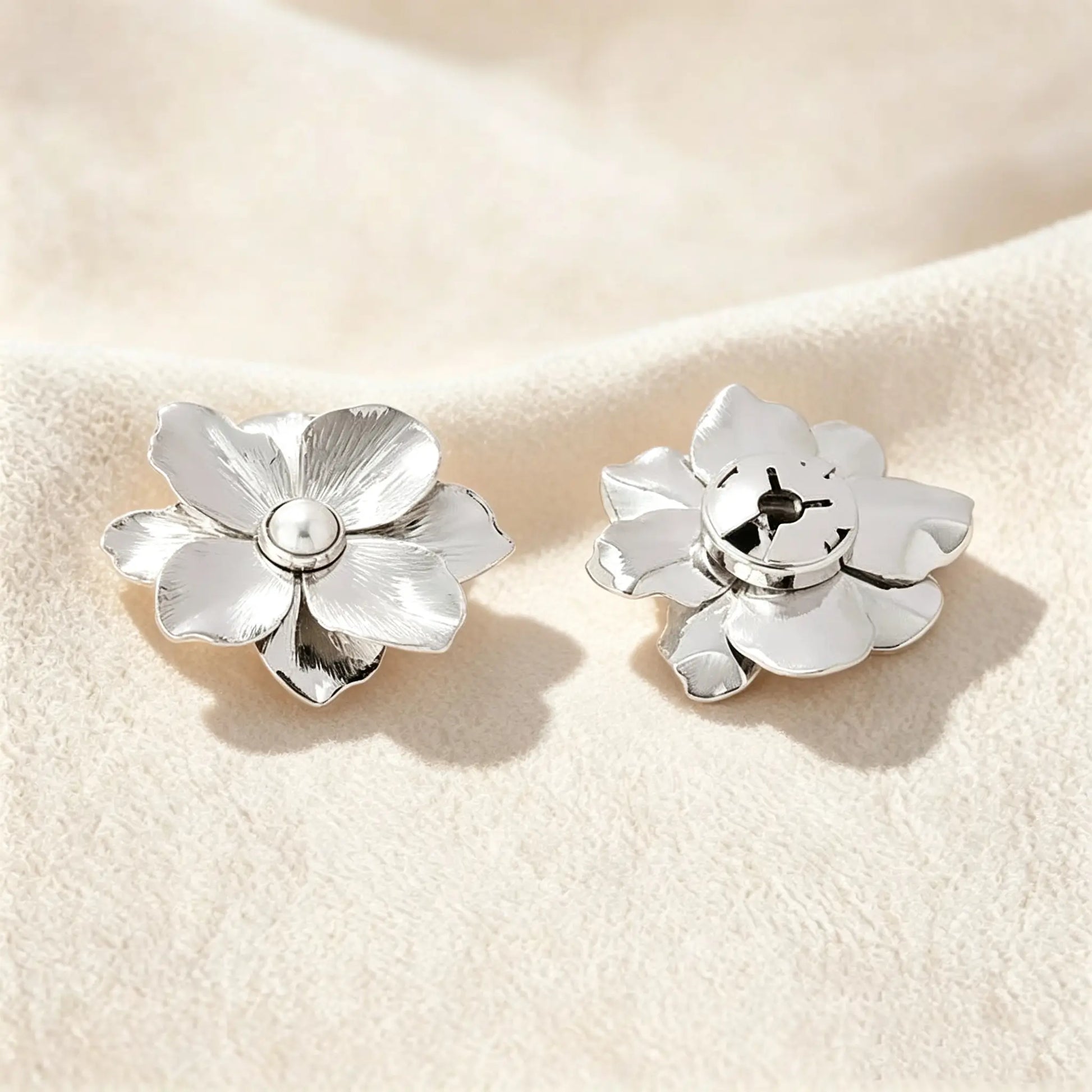 Detailed view of a refined silver floral button cover. The right side shows the securely closed clip mechanism, ensuring a 1:1 standard button scale for a sophisticated, no-sew faux cufflink experience.