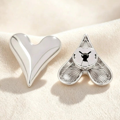 Detailed back view of a polished silver heart button cover. The firmly closed mechanism guarantees a secure grip on the button, providing a sleek jewelry finish for modern wardrobes without damaging fabrics.