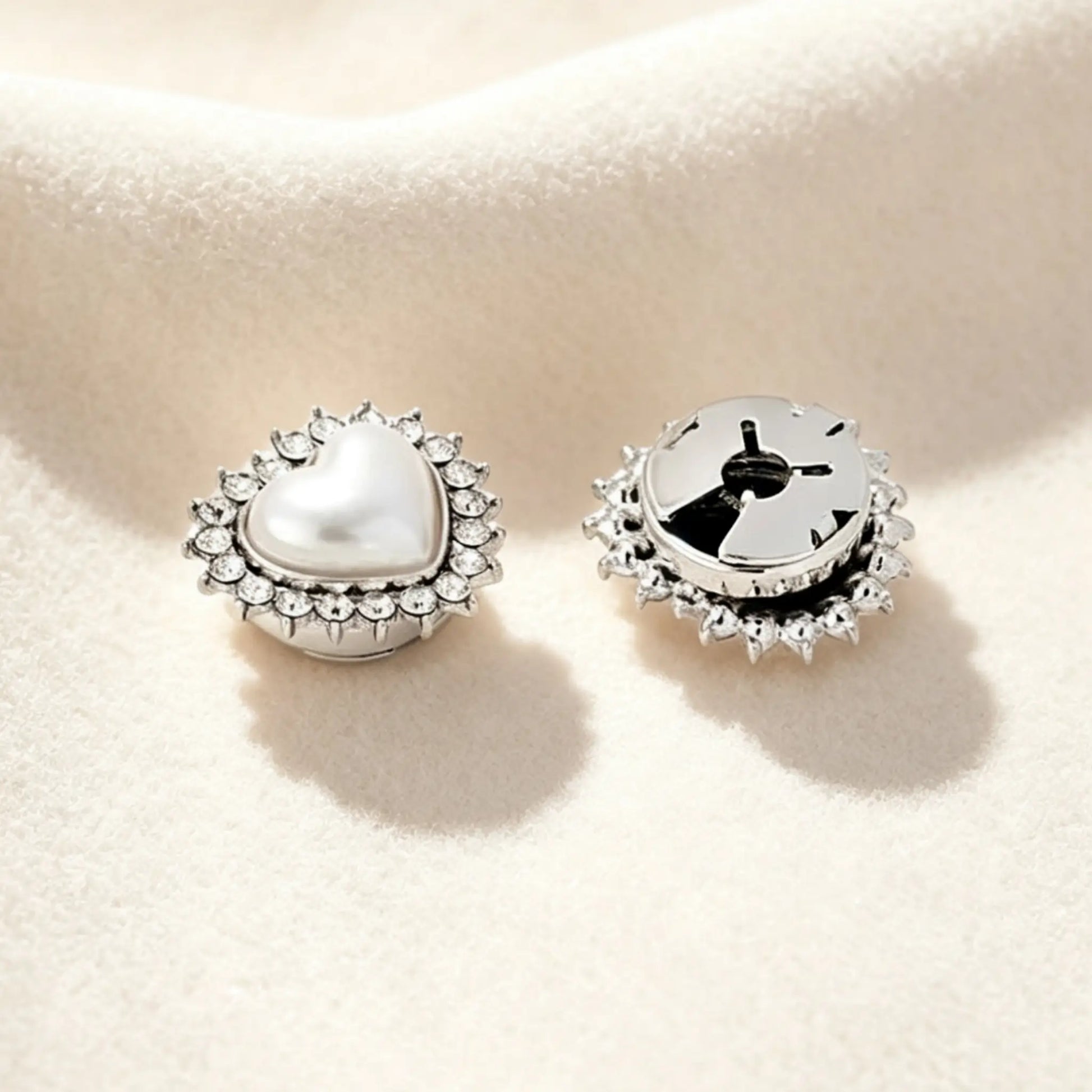 Detailed view of a refined silver heart button cover. The right piece shows the firmly closed clip mechanism, guaranteeing a sophisticated 1:1 button scale and a secure fit for modern shirt cuffs.