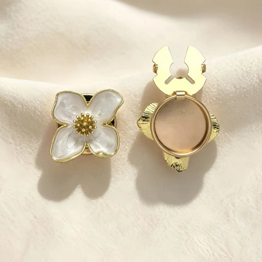 Light luxury pearl white enamel four-petal floral button cover with a detailed gold center. Displayed with the gold attachment clip fully open, offering an effortless and no-sew shirt cuff upgrade.