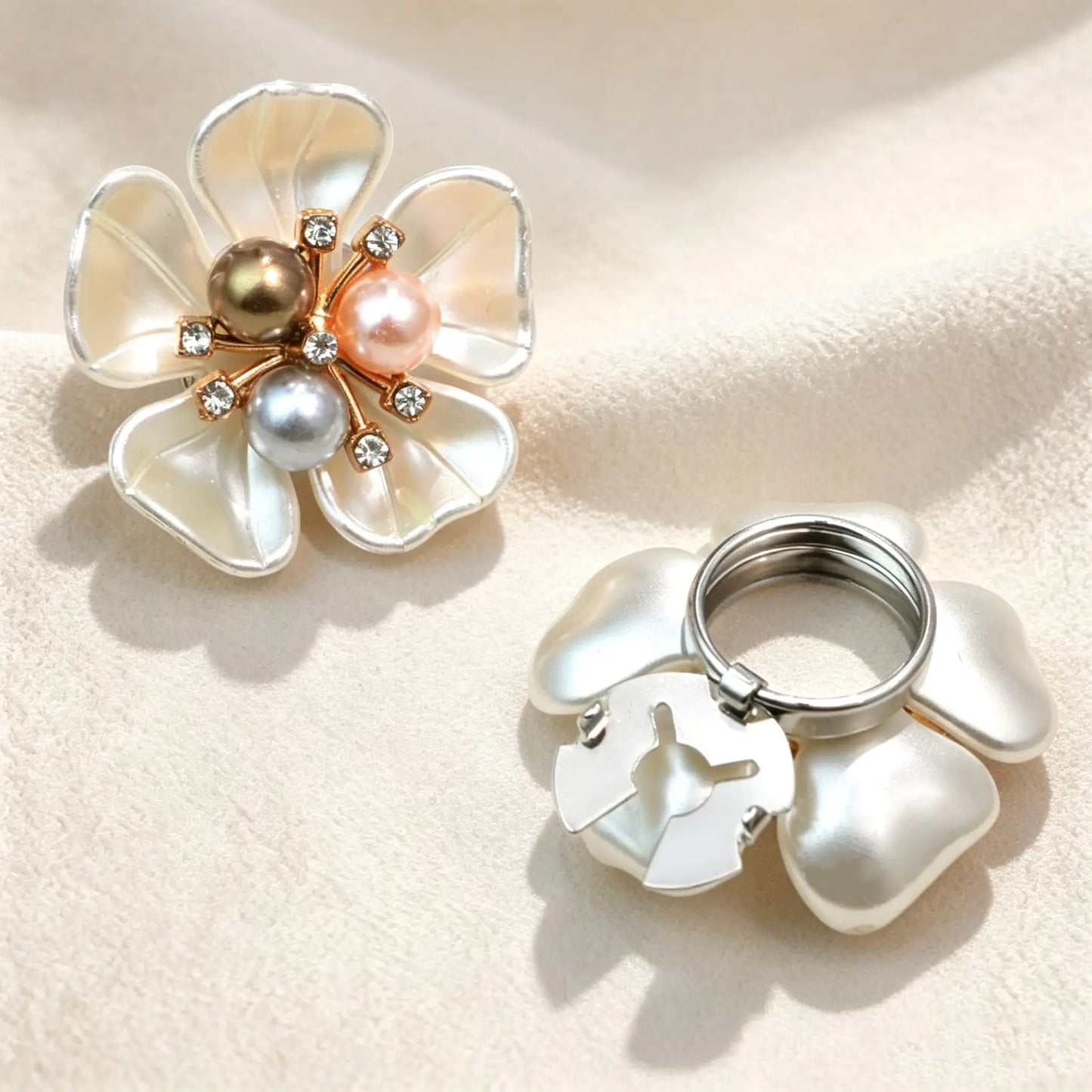 French-style pearlescent white floral button cover featuring a unique cluster of three mixed-color pearls in bronze, pink, and silver tones. Paired with a view of the open silver attachment clip.