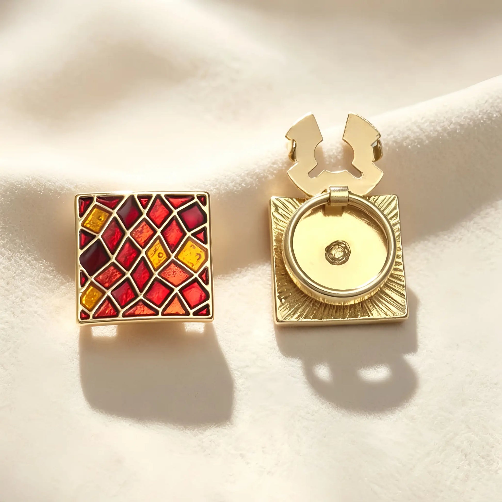 Detailed view of a vintage-style square button cover showcasing a geometric red enamel lattice design. The image emphasizes the open gold hinge mechanism, demonstrating how easily it attaches to standard shirts as a no-sew cuff accessory.