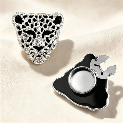 A sleek silver panther button cover with black enamel details and sparkling crystals, featuring a secure hinge mechanism for a stylish, no-sew shirt upgrade.