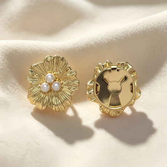 A pair of light luxury textured gold floral button covers with a three-pearl center. The right piece highlights the secure closed gold back, perfectly functioning as a sophisticated and detachable cuff accessory.