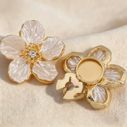 A pair of unisex camellia button covers that can also be used as cufflinks or collar pins, highlighting the versatile and premium materials.