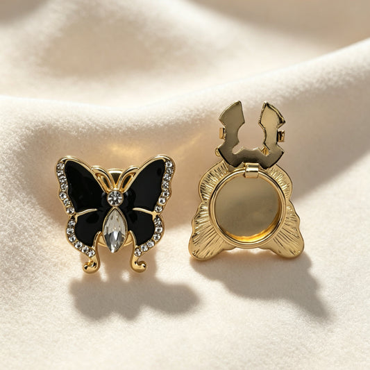 Detailed view of a vintage-style black butterfly cuff accessory with sparkling rhinestones. The right side displays the open gold hinge mechanism, demonstrating a quick, no-sew French cuff upgrade.
