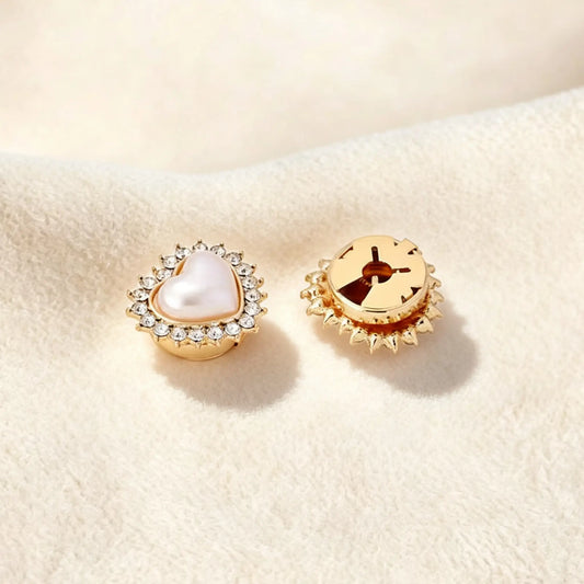 Close-up of a perfectly scaled gold pearl heart faux cufflink on a cream background. The image highlights the secure closed backing, ensuring the accessory lays flat against the cuff for a seamless, zero-bulk jewelry finish.