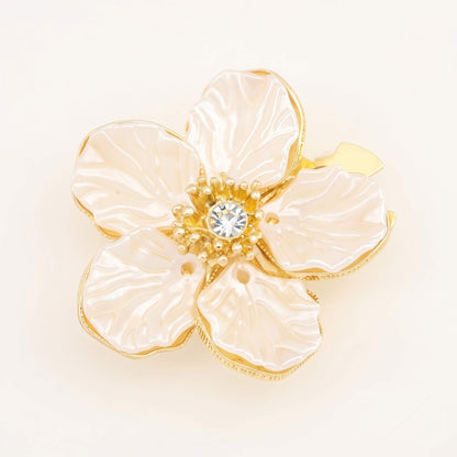 A premium white camellia button cover featuring imitation pearl petals and a 14K gold-plated frame with a shiny cubic zirconia center.