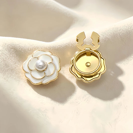 Classic white enamel camellia floral button cover featuring a central pearl and delicate gold outlines. Accompanied by a clear view of the open gold hinge mechanism, offering an effortless light luxury cuff transformation.