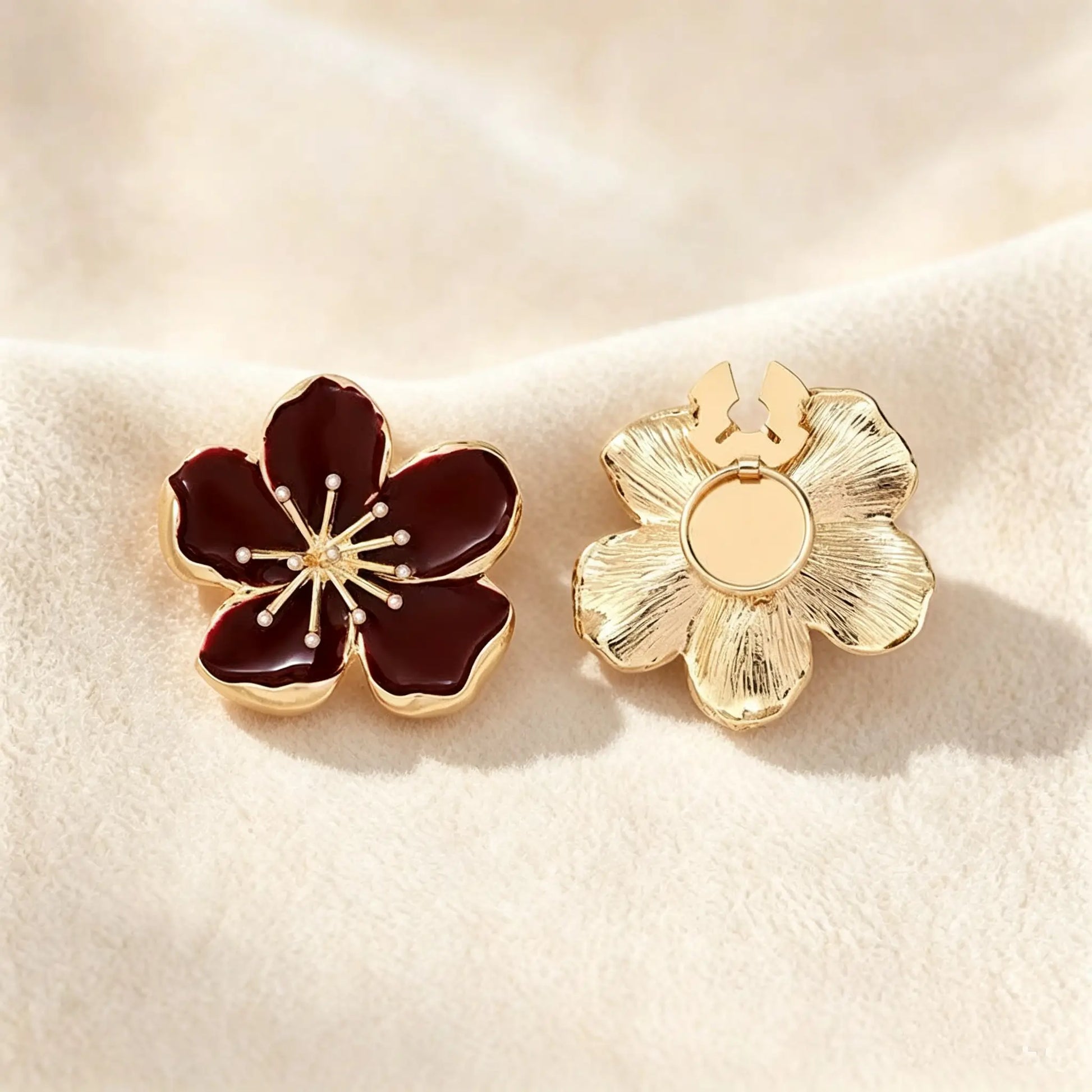 Detailed view of a deep wine red enamel floral button cover. The right piece displays the securely closed attachment mechanism and its textured gold finish, guaranteeing a refined, realistically proportioned upgrade for modern shirt cuffs.